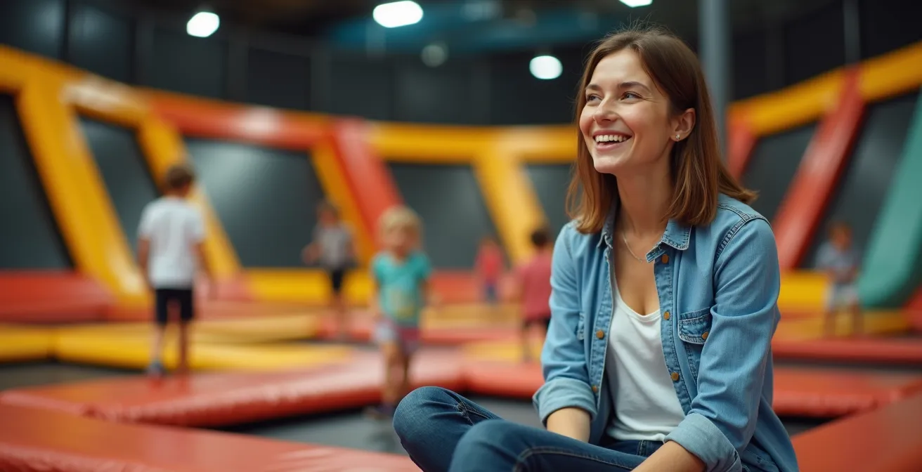 Un parent détendu en arrière-plan, souriant, regardant les enfants s'amuser dans le parc de trampolines, symbole de la sérénité retrouvée
